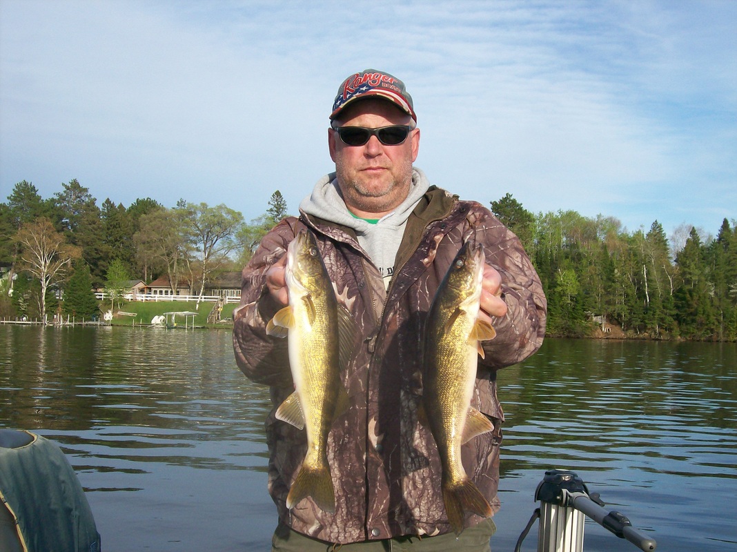 Fishing guide Colin Crawford holding two walleyes